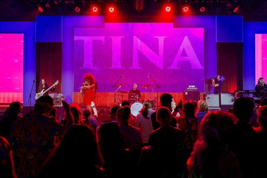 Tina Turner impersonator on stage in front of a crowded dance floor